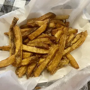 a basket of french fries on a checkered tablecloth