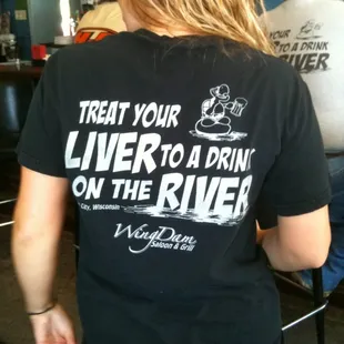 a woman wearing a t - shirt that says treat your liver to drink on the river