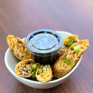 a bowl of food with dipping sauce