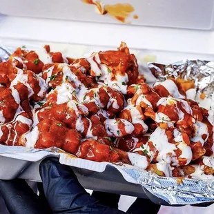 a tray of wings covered in sauce