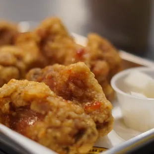 a tray of fried food with dipping sauce