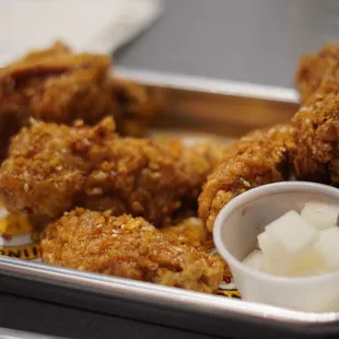 a tray of fried chicken with dipping sauce