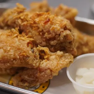 a tray of fried chicken with a side of sour cream