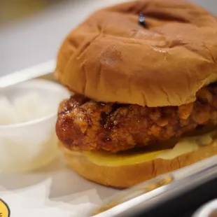 a chicken sandwich with a side of sour cream