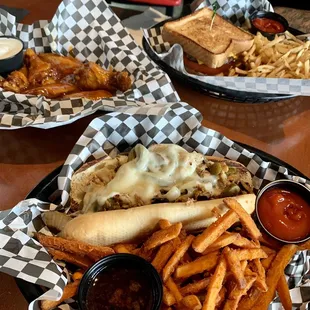 Chicken cheesesteak w/ sweet potato fries, cheeseburger on Texas toast w/ fries, and mango habanero wings with house made blue cheese