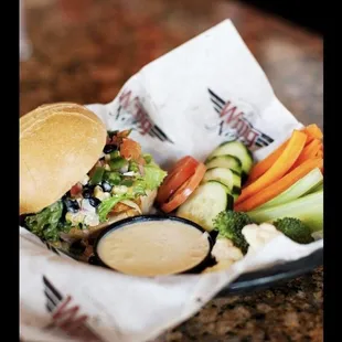 a sandwich and vegetables in a basket