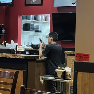 Waiter on cell phone while our cups need refilled.