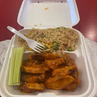 a plastic takeout container with rice, celery, and a fork