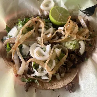 The three carne asada tacos with everything on it