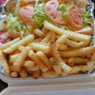 Cheese steak sub, lots of toppings, French fries.