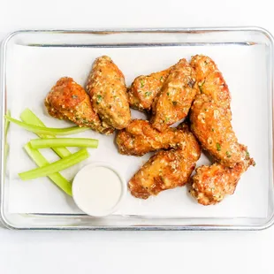 a plate of chicken wings and celery sticks