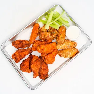a tray of chicken wings and celery sticks