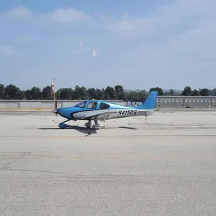 a small blue and white airplane on the tarmac