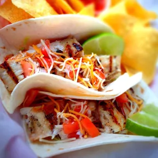 two tacoss and chips on a plate