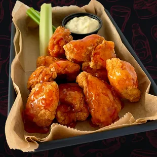 a tray of chicken wings and celery