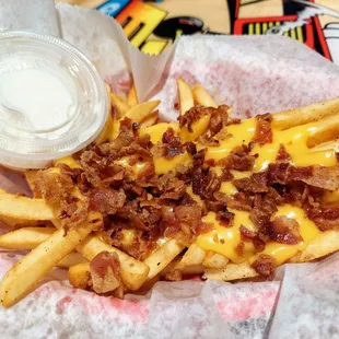 a basket of fries with bacon and cheese