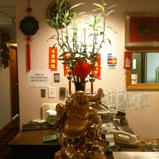 a gold buddha vase with flowers in it