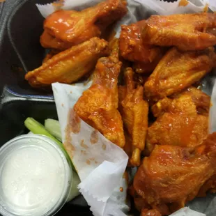a tray of chicken wings with dipping sauce