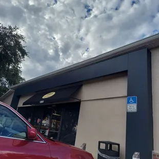 a red car parked in front of a building