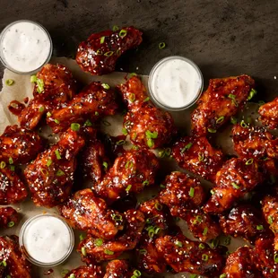 a platter of wings with dipping sauces