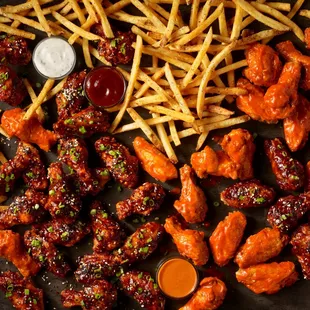 a tray of chicken wings and french fries