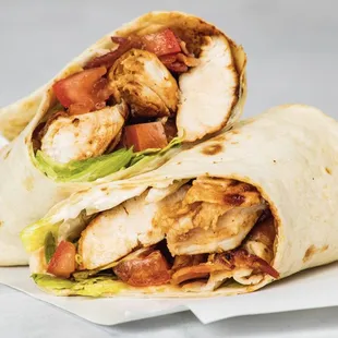 a chicken wrap with lettuce and tomatoes