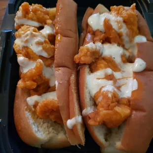 Crispy chicken tender sandwiches tossed in buffalo sauce with ranch drizzled on top