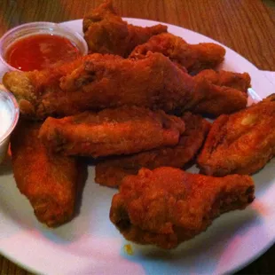 a plate of chicken wings with dipping sauce