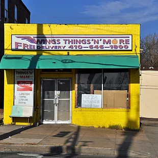 a yellow building with a green awning
