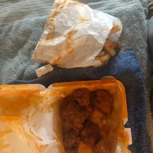 Wings and fries covered in sauce