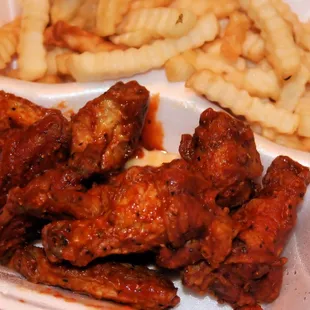 a tray of chicken wings and french fries