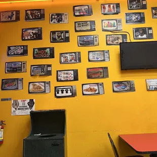 a yellow wall with pictures and a television