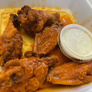 a tray of chicken wings with sauce