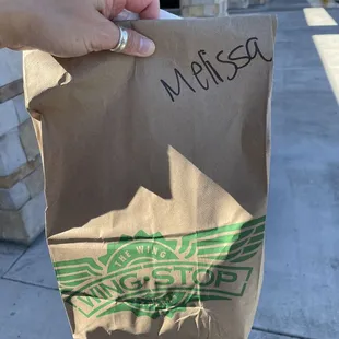 a hand holding a bag of food