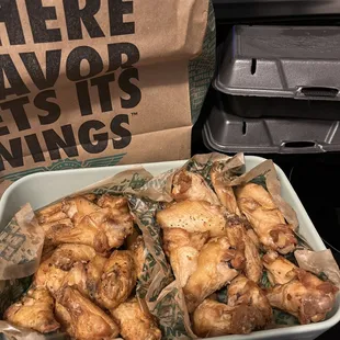 a bag of chicken wings sitting on a stove