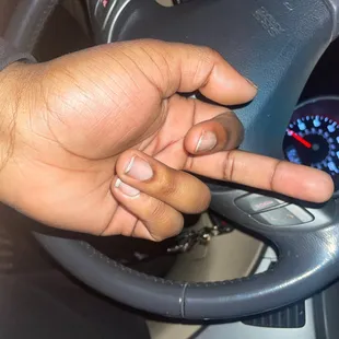a hand on the steering wheel of a car