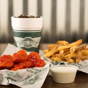 two baskets of chicken wings and a cup of ketchup
