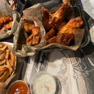 a tray of chicken wings and french fries
