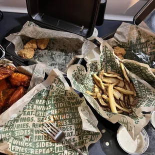 a tray of chicken wings and fries