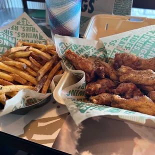 a tray of chicken wings and french fries