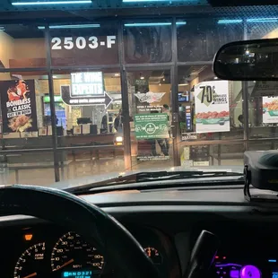 the inside of a car with a view of a fast food restaurant