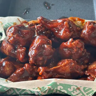 a tray of chicken wings with sauce