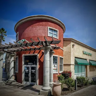 the outside of a restaurant with a pergol roof