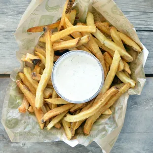 a basket of french fries with a dip