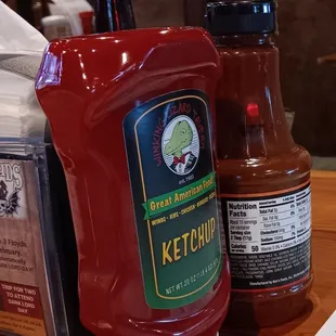 a ketchup container and a bottle of ketchup