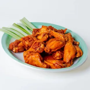 a plate of buffalo wings with celery