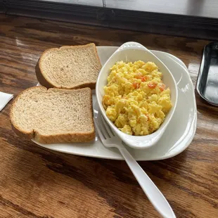 a bowl of scrambled eggs with bread