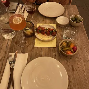 Arancinis, pickles, olives, tumeric aperol spritz, and a cocktail with a cayenne pepper (I forget!)