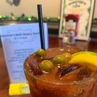 a bloody drink with olives and a lemon
