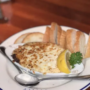 a plate of food with bread and lemon wedges